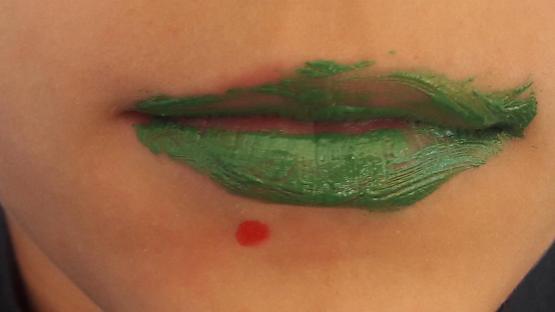Gesicht Schminke roter Punkt Pickel. grüne Lippen